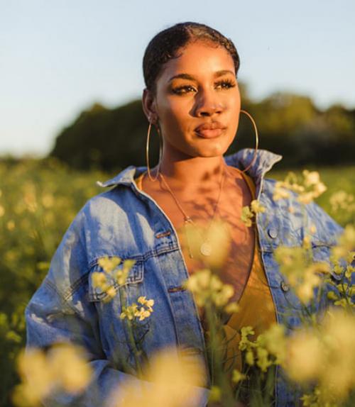  Black woman standing in field of flowers