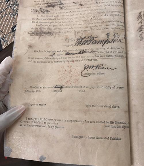 gloved hand holding an antique document
