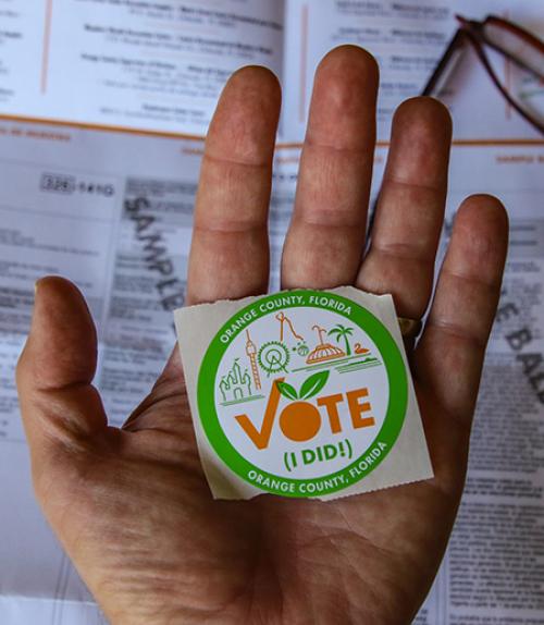  Hand holding a &quot;Vote&quot; sticker