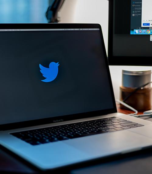 Laptop showing blue bird Twitter logo on a black screen
