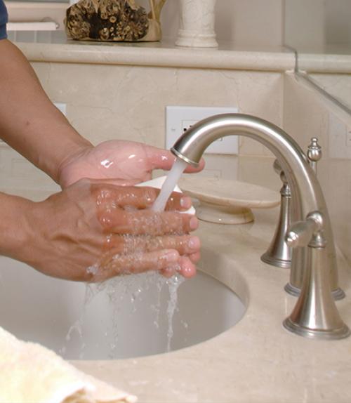  hands under a faucet with soap