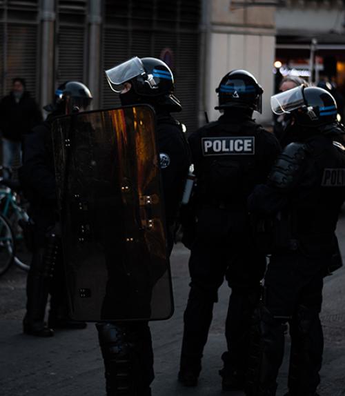 Four police in black, with shields and helmets