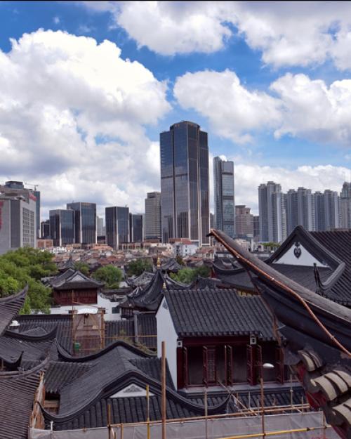 		A traditional style Chinese style building leading into a collection of modern skyscrapers in Shanghai
	