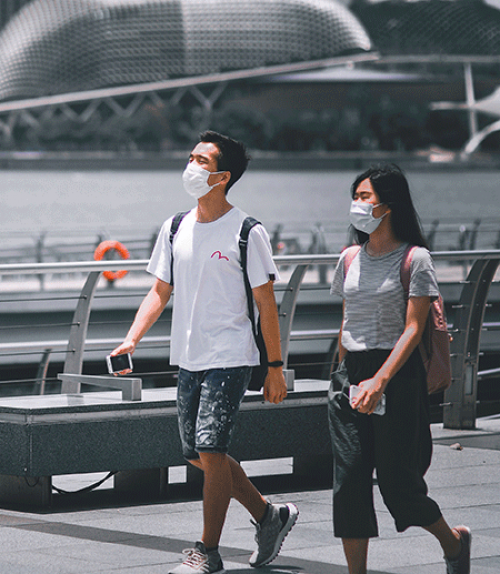  Two people walking, wearing masks