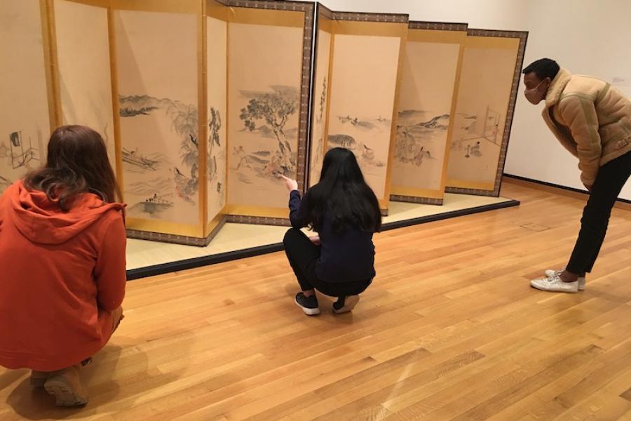 Students viewing art on a Japanese screen