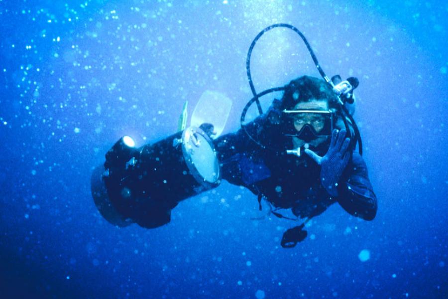 Person in scuba gear surrounded by blue water