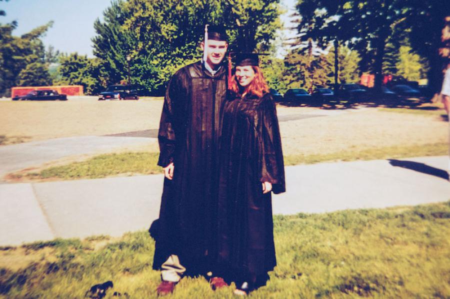 Two college graduates in caps and gowns.