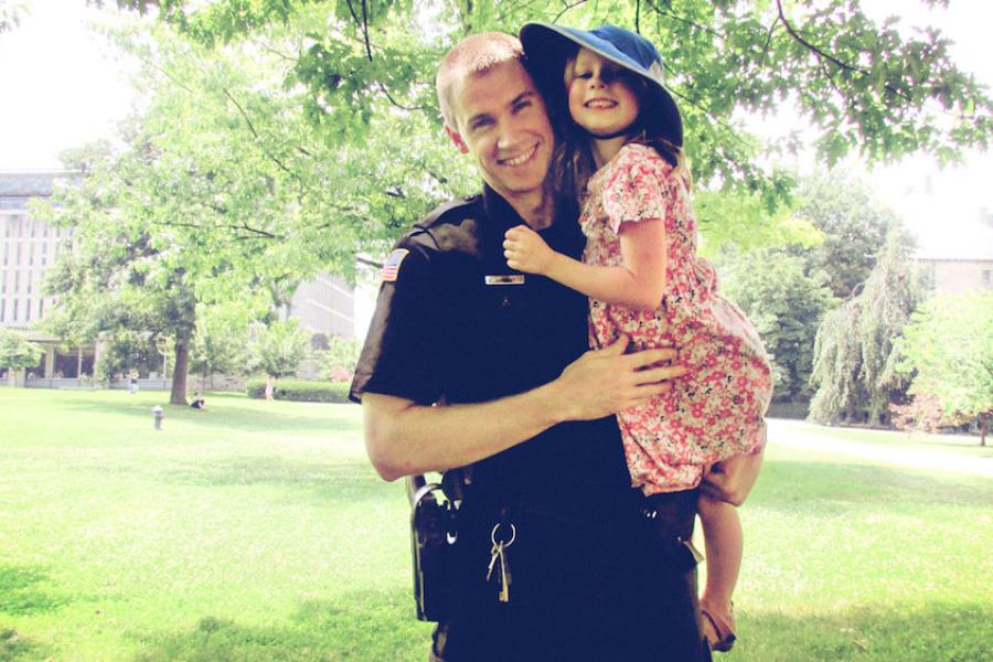 man in police uniform holding a little girl