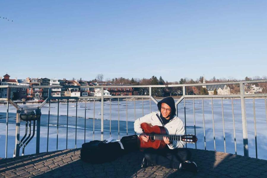 person playing guitar on pier