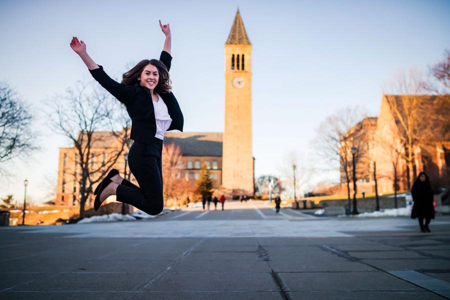 person jumping by clock tower