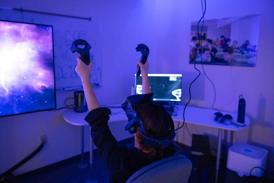 person wearing VR headset with arms up in the air