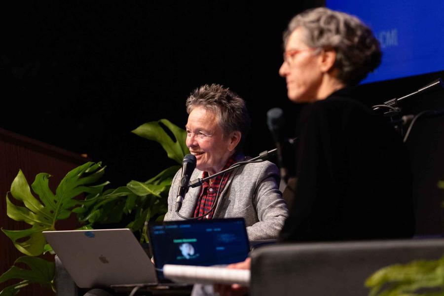 two women sitting on stage
