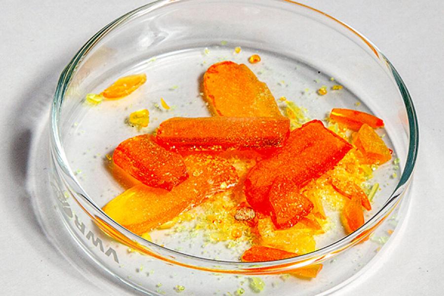 Orange material in a clear glass lab dish