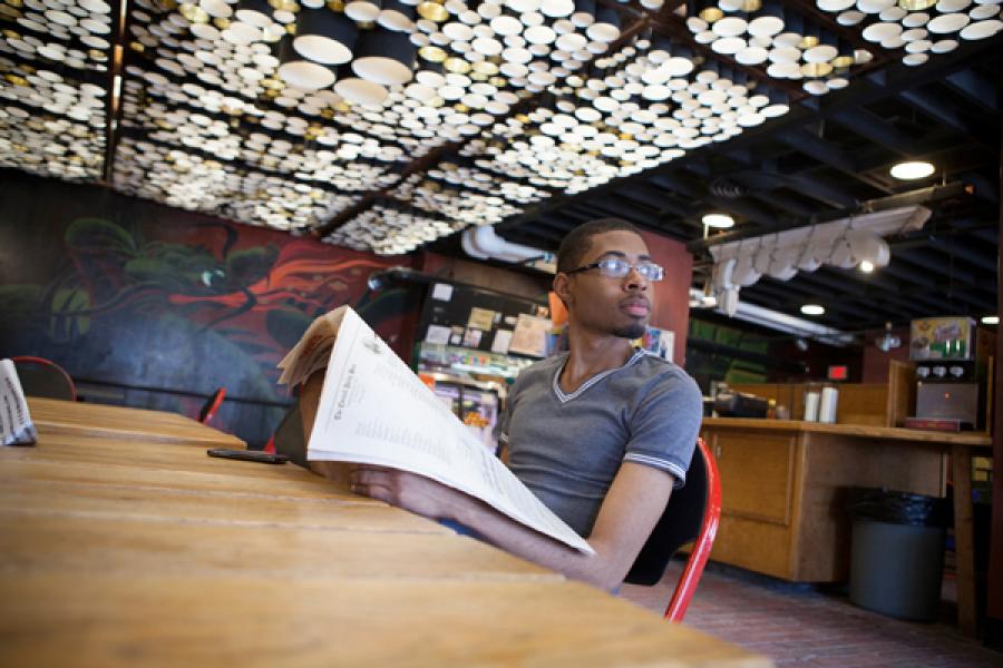Student reads the newspaper at Green Dragon Cafe