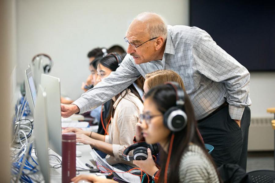 Richard Feldman pointing at a computer screen at which a student sits at the LRC