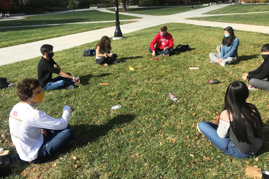 People sit in a circle on the grass