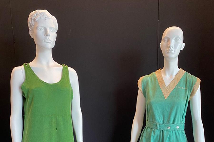 Two mannequins wearing green suits