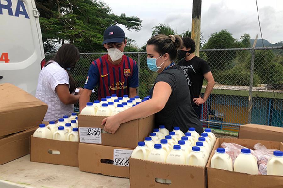Joey Ibanez, left, unloads milk during a delivery, helped by his cousin, right, Isabell Junqueria.
