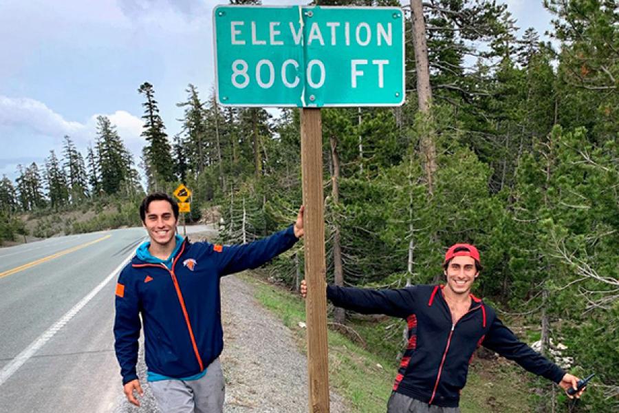 Two people flank a sign: 8,000 feet