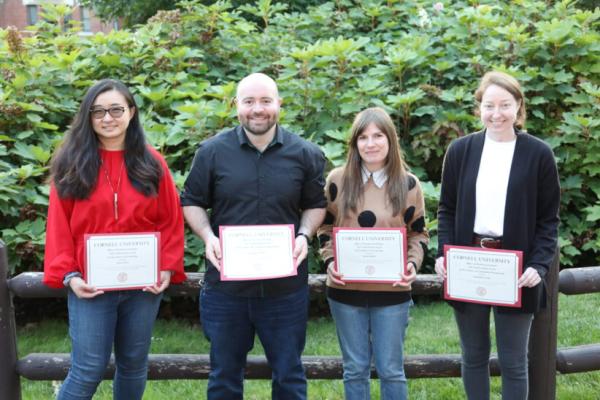 four people holding certificates