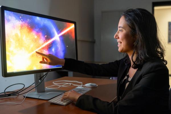 Person pointing to a brightly lit, colorful computer schreen