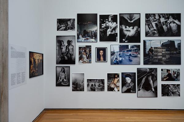 Images, most of them black and white, hung on a white museum wall