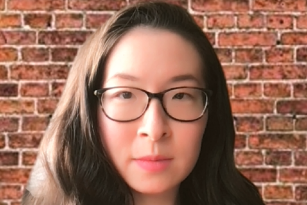 Rhoda Feng, wearing big black glasses, long hair and a serious expression