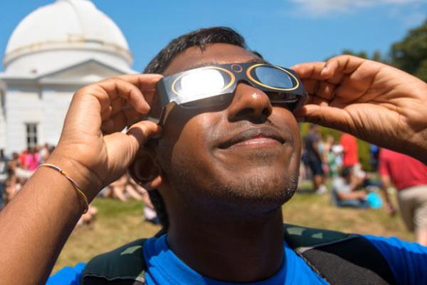 Student observing solar eclipse with special glasses