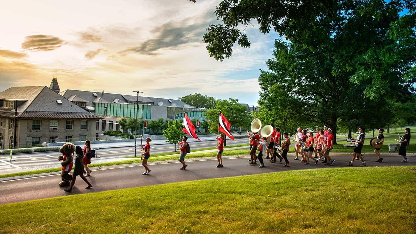 Students in the Big Red Band march past Klarman Hall
