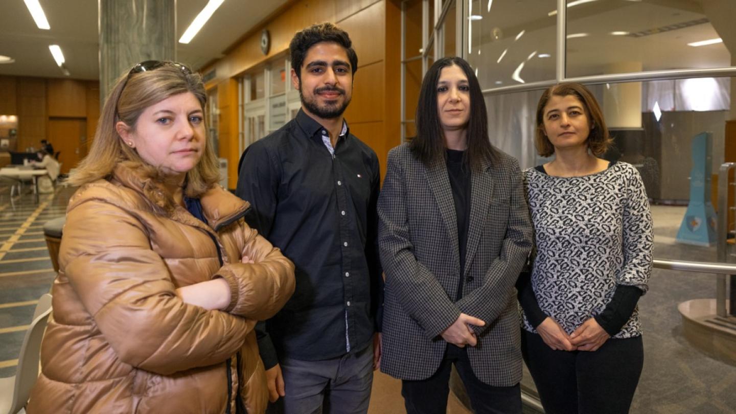 Four people looking somber