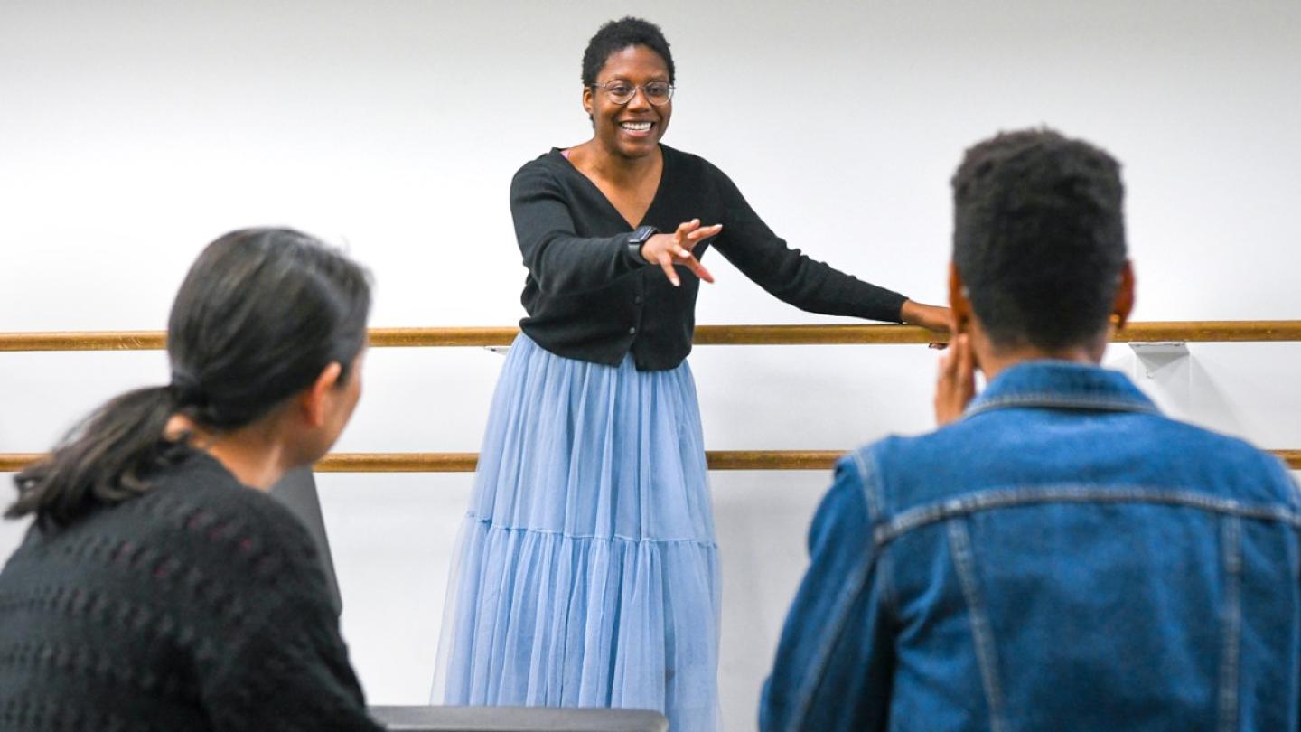 Person gesturing to two others: a theatre director at work
