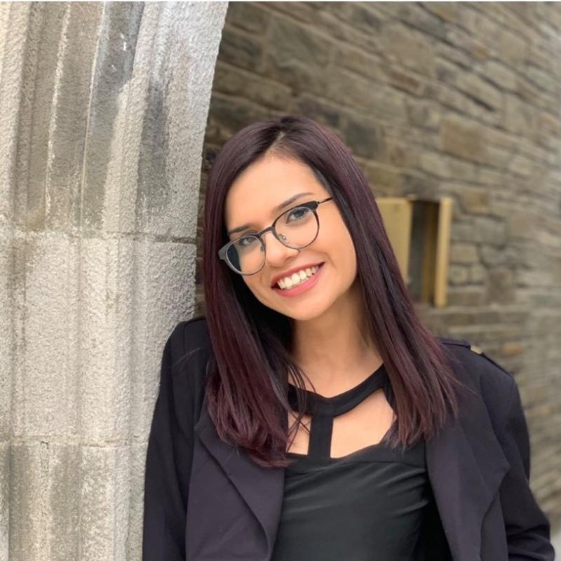 Lucero Contreras '21 in a black blouse, leaning on a gothic arch.