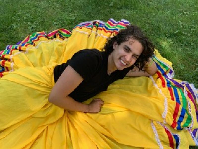 Marco Antonio Peralta-Ochoa '21 wearing a yellow skirt with ribbon trimmings.