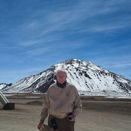 Fred Young ’64, M.Eng. ’66, MBA ’66 in front of the summit of Cerro Chajnantor in the Atacama Desert of northern Chile, site for the Fred Young Submillimeter Telescope.
