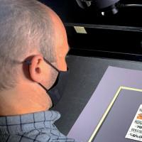 Person looking down at print materinal on a scanner