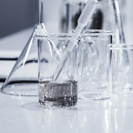 		Glass beakers on a table, one partially filled with liquid
	