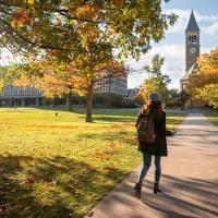 Student walks on Arts Quad in fall