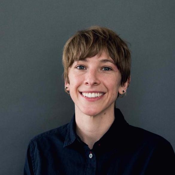Natalie Wolchover wearing a blck shirt and earrings