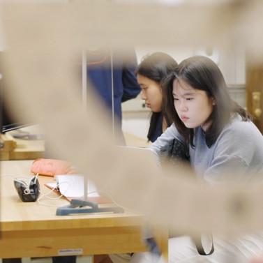 Person looks carefully at physics lab equipment