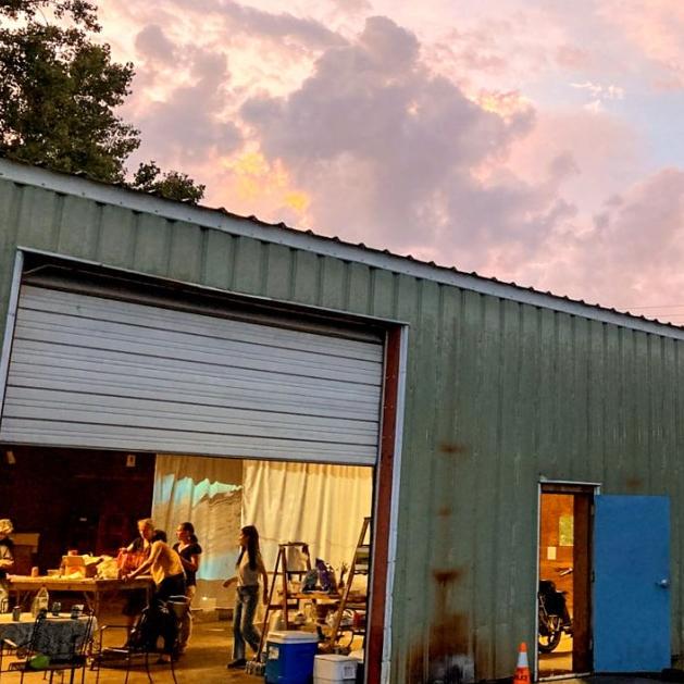 		Barn-like building with open doors, lit within
	