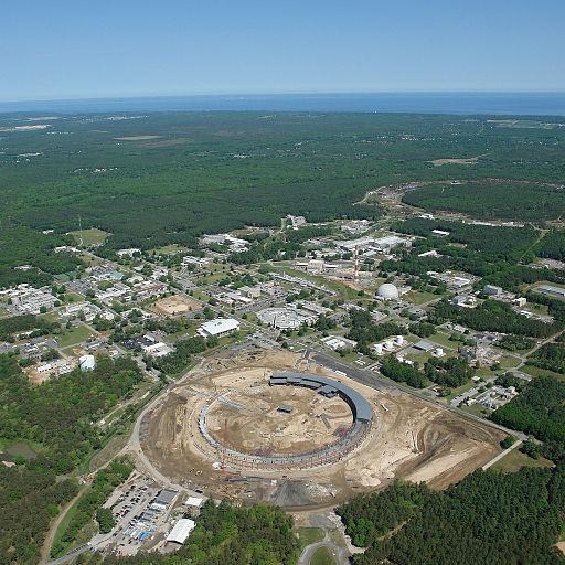 The circular accelerator ringed by buildings surrounded by a vast area of solid trees