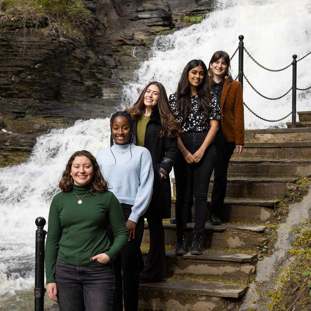 Students standing on a staircase overlooking a waterfall