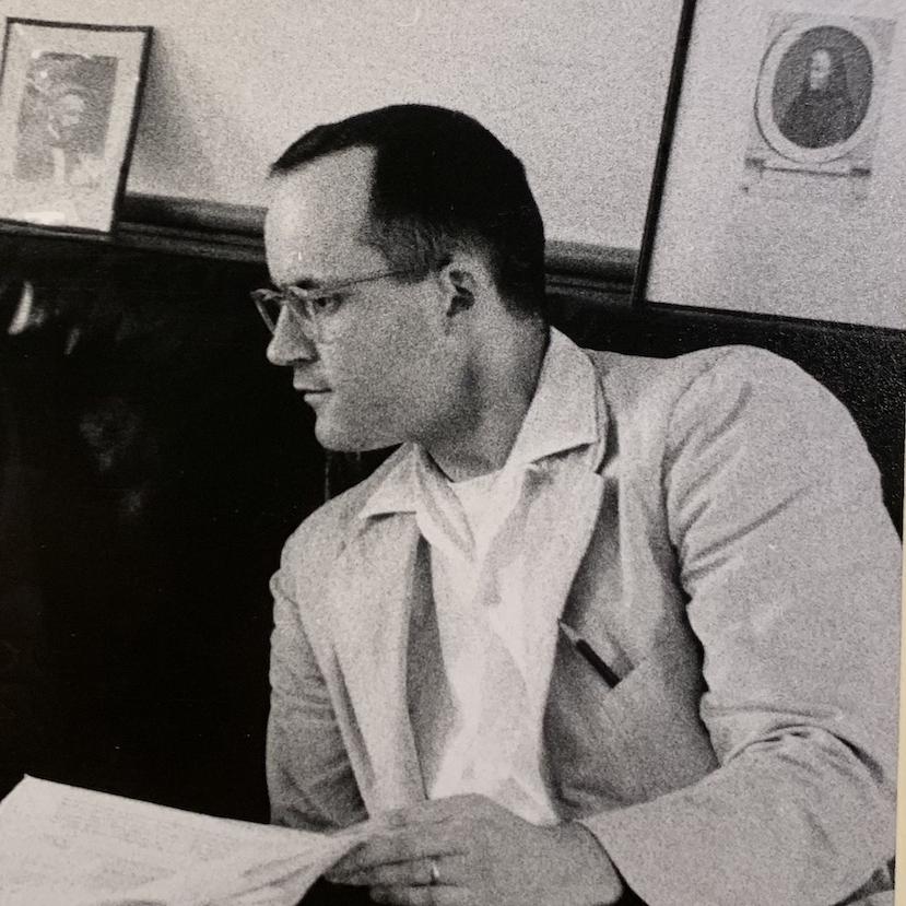 Historical black and white image of a young man reading