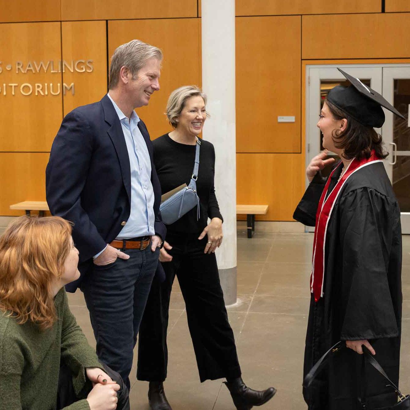 people in grad robes with their family