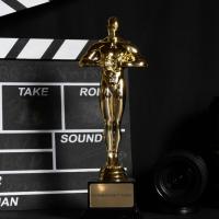 Gold "Oscar" statuette in front of a film take board