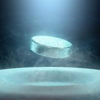 		metal puck levitates above a slightly pitted white surface
	