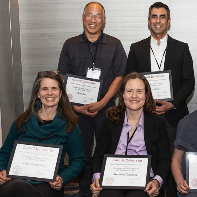 		Eight people in two rows, each displaying an award certificate
	