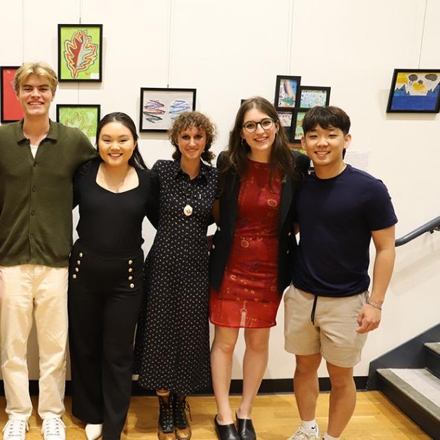 		Eight people stand together in an art gallery
	
