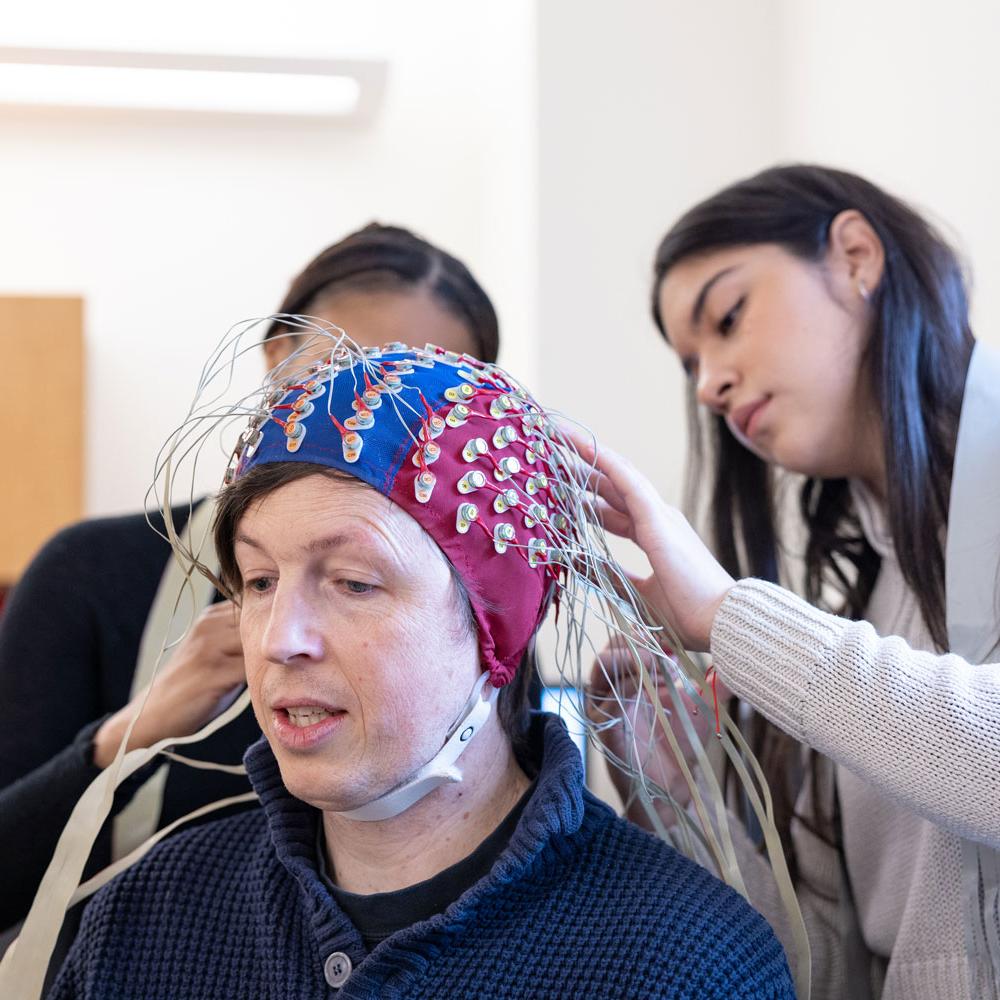 		students place EEG nodes on a study participant
	