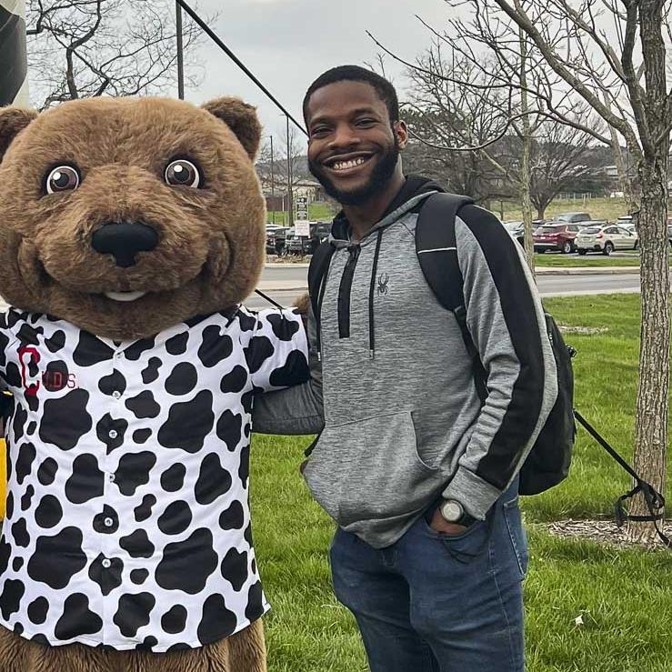 Daniel stands next to Touchdown the bear.